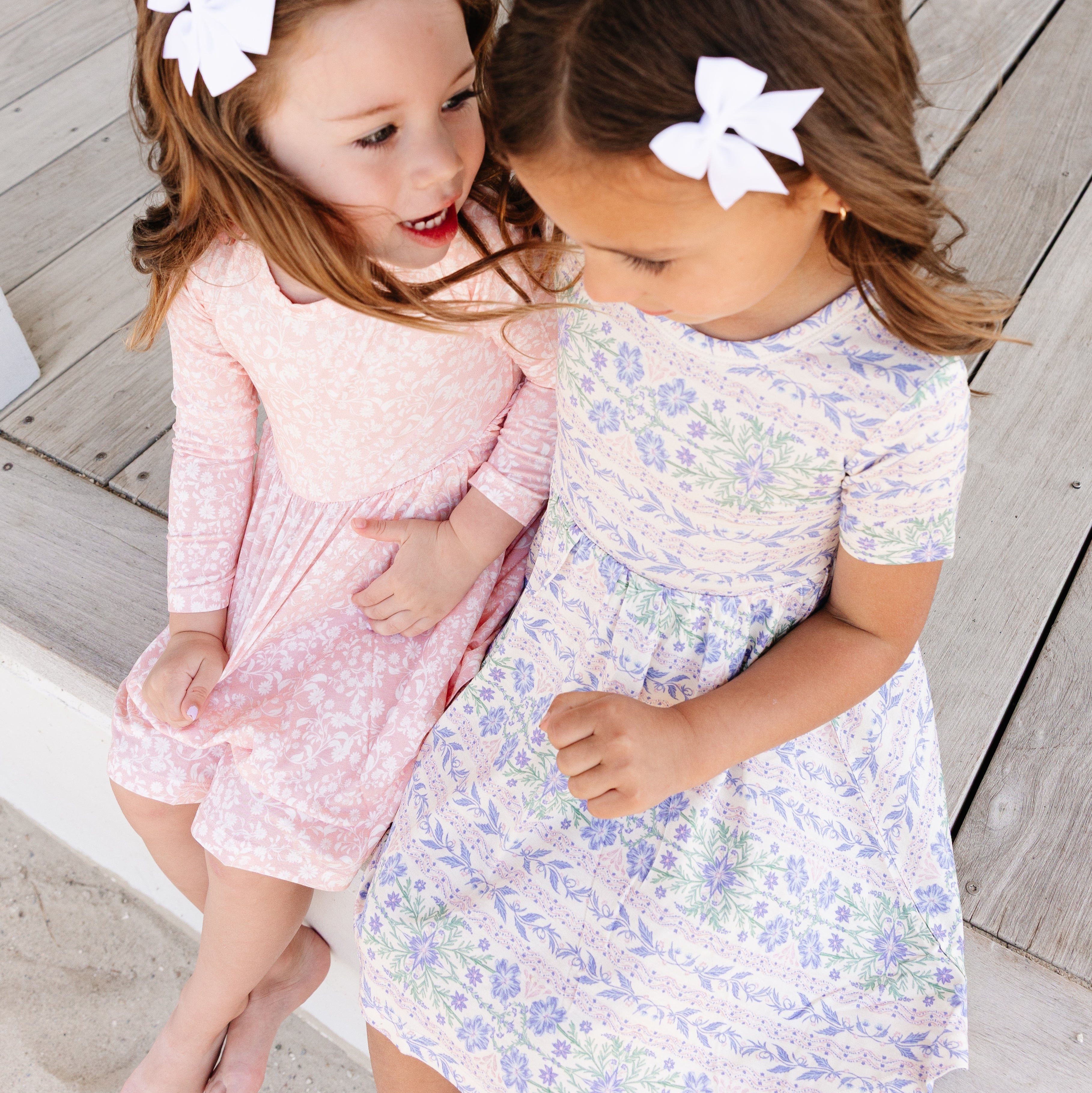 Two young girls in bamboo twirl floral dresses