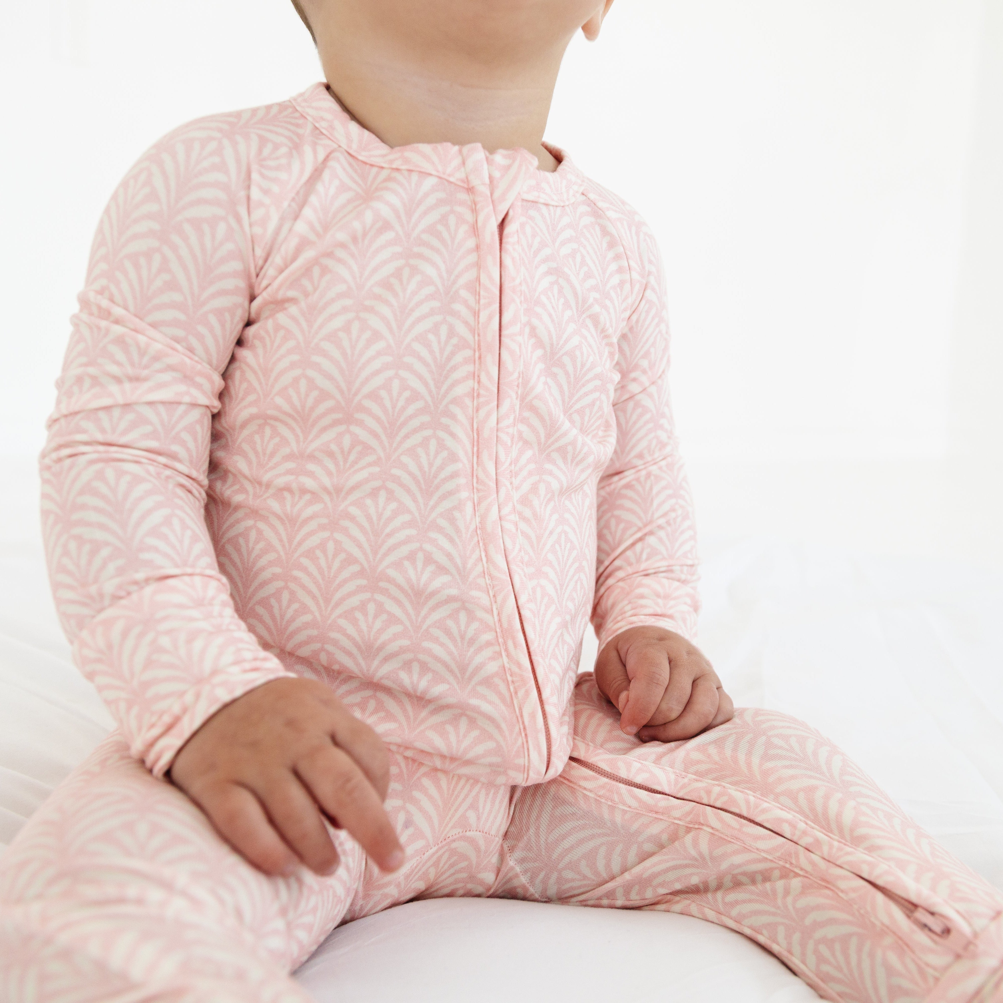 pink floral sleeper, highlighting the flowy leaf pattern and cozy fit