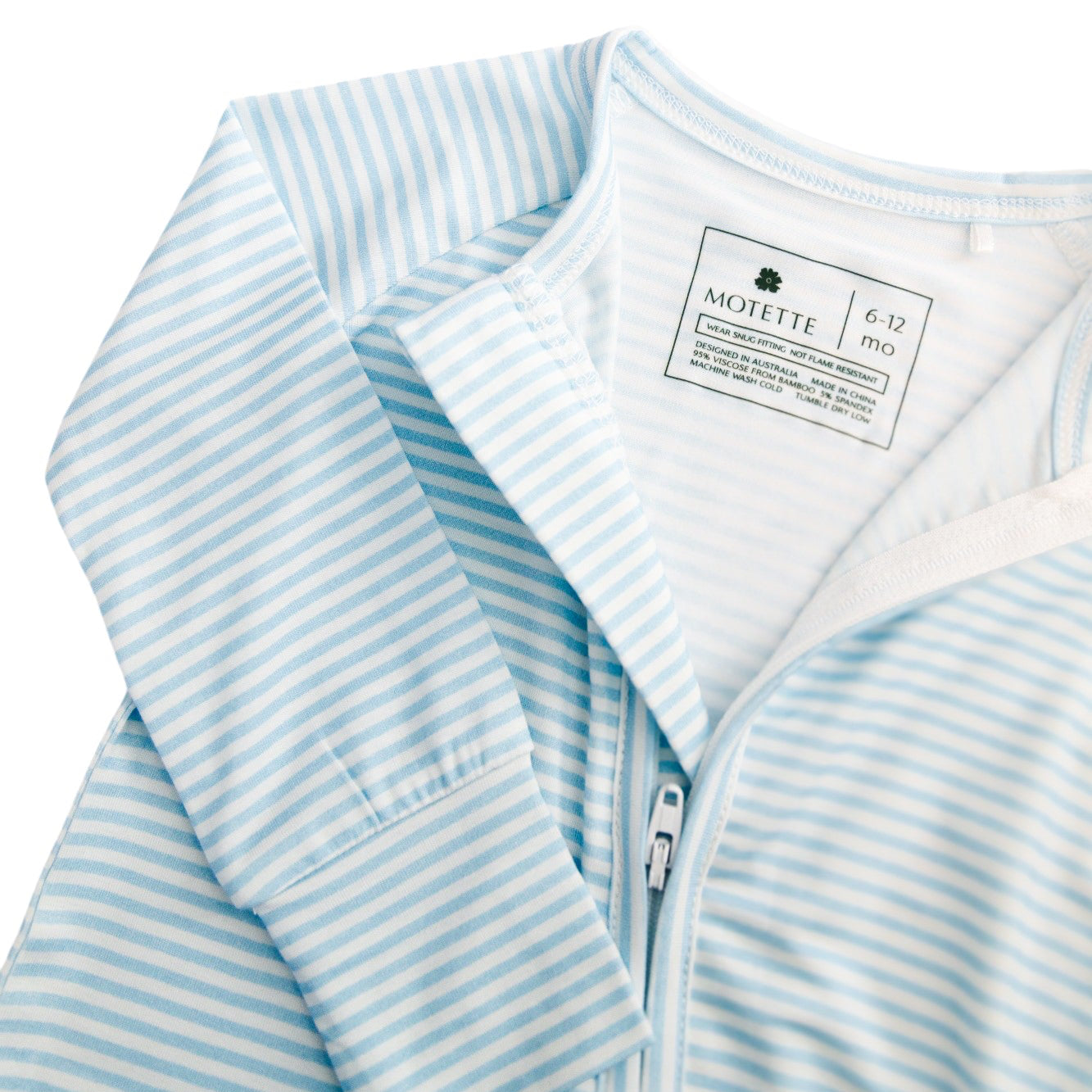 Flat lay of the Seaside Stripe sleeper with a matching lay ball, styled to show the softness and stripe detail.