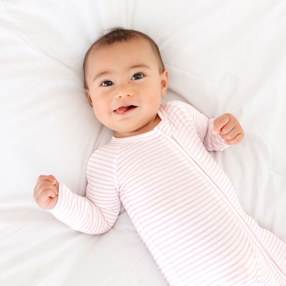Baby relaxing in Ballet Stripe Bamboo Sleeper by Motette – coordinated sibling set and top-rated for eczema-prone skin