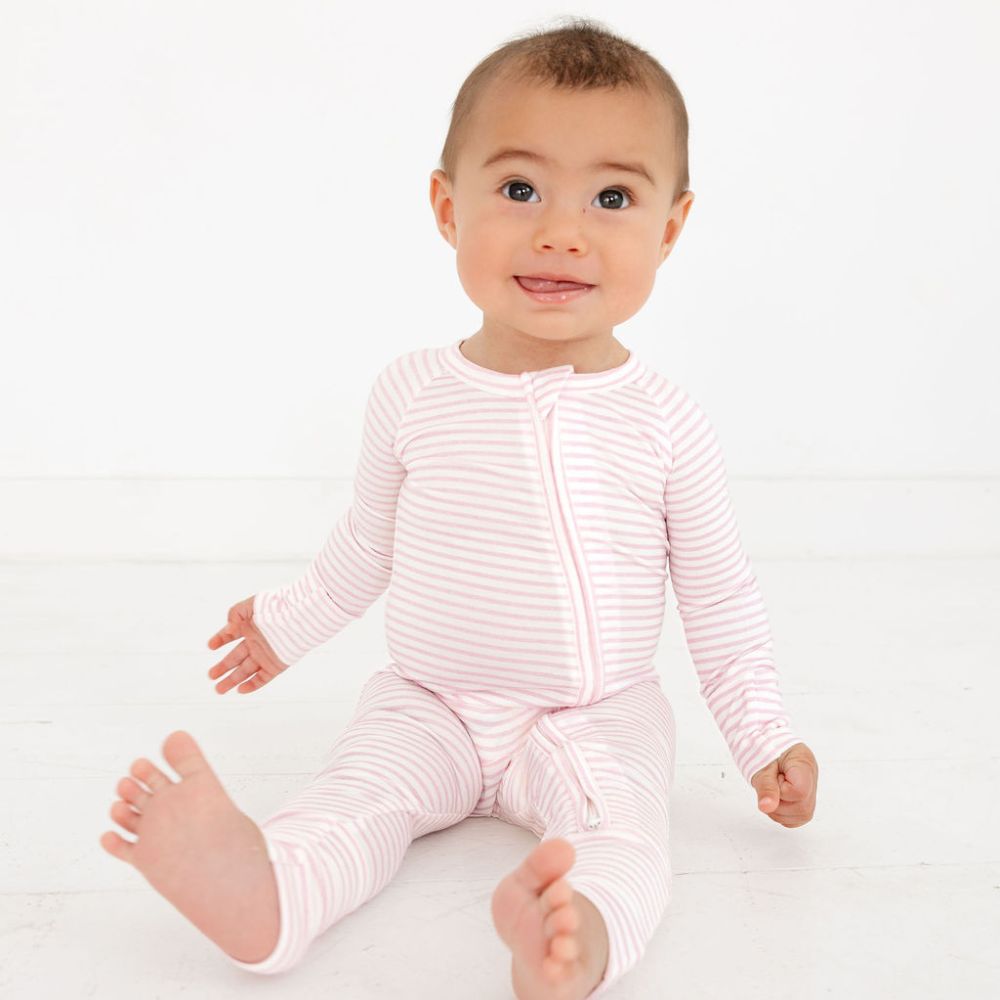 Baby in Ballet Stripe Bamboo Sleeper sitting on white floor – eczema friendly bamboo pajamas by Motette, soft on sensitive skin
