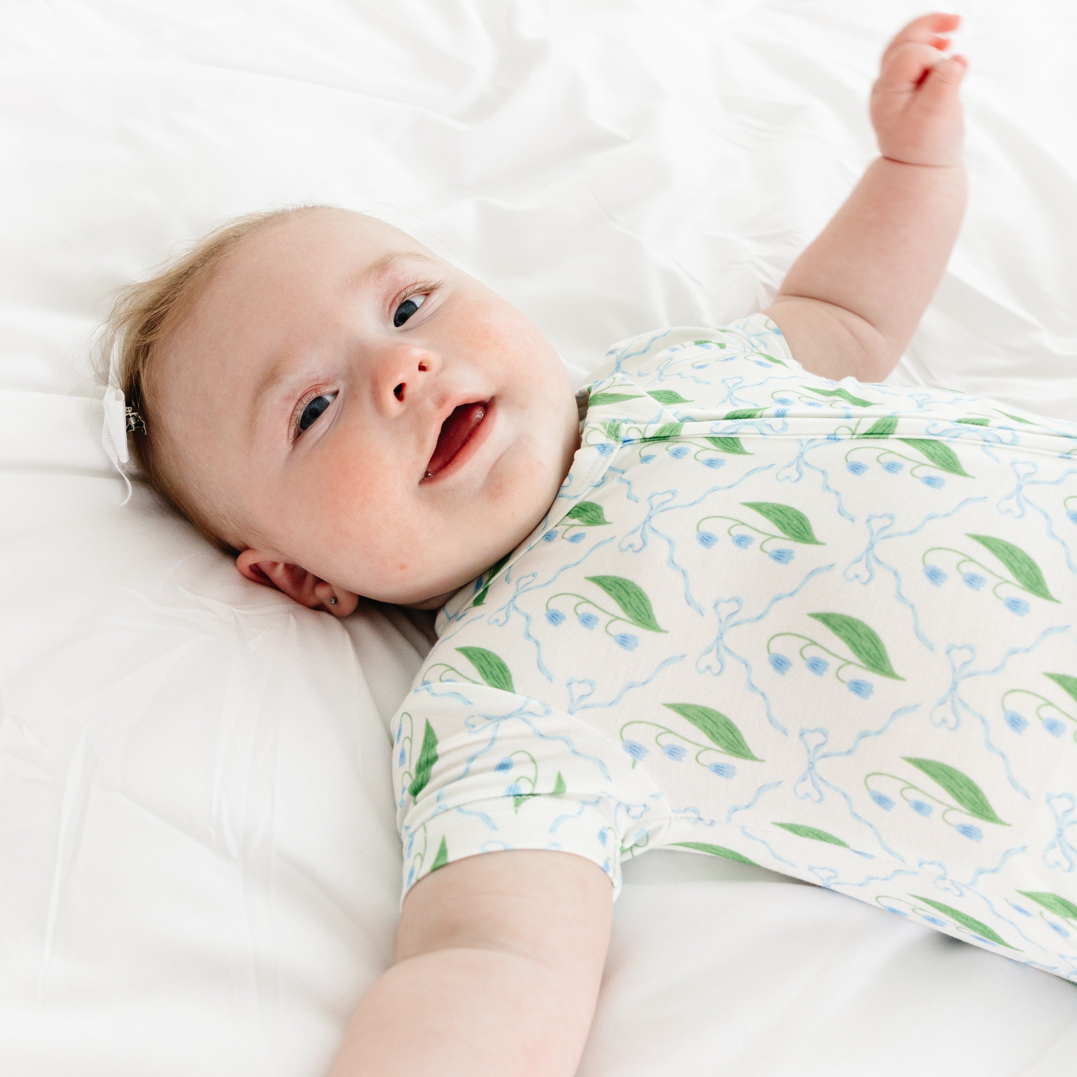 Baby happily smiling in the Bluebell Bows Short Sleeve & Shorts Bamboo Sleeper by Motette