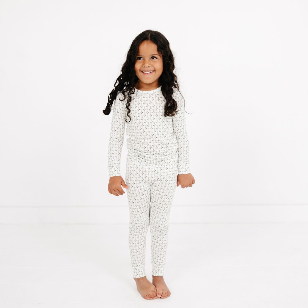 Little girl smiling and standing wearing Motette Lavender Lane Bamboo Kids Pajama Set.