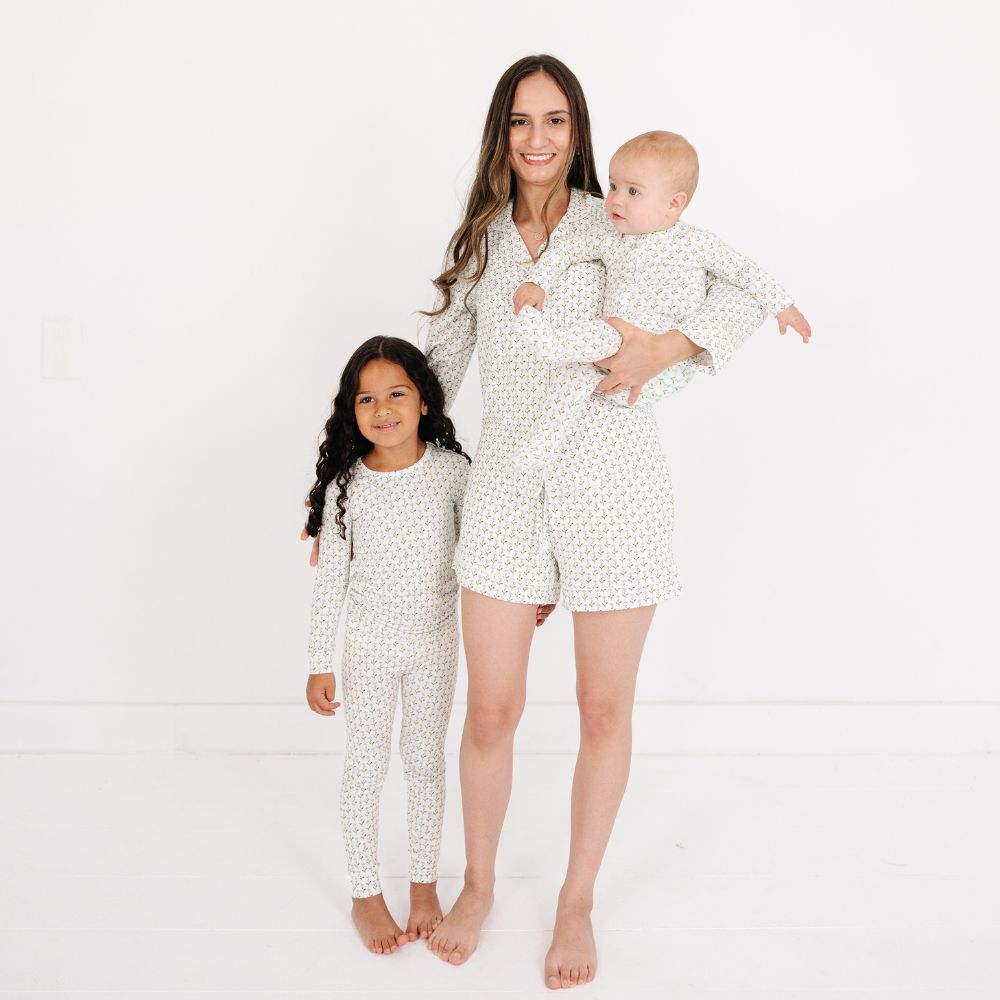 Mommy holding baby and standing beside daughter, all wearing matching Motette Lavender Lane Bamboo Pajama Sets.