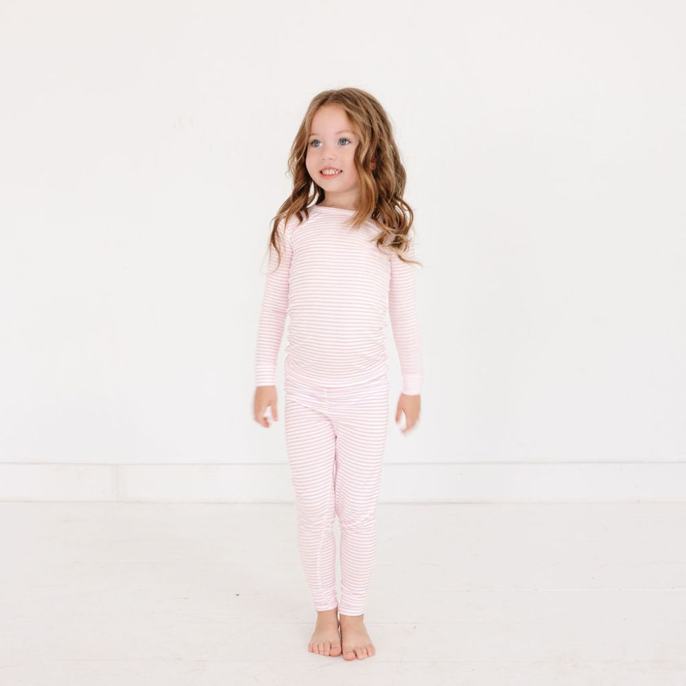 Toddler girl standing in Ballet Stripe bamboo pajamas – eczema friendly and perfect for sibling matching looks by Motette