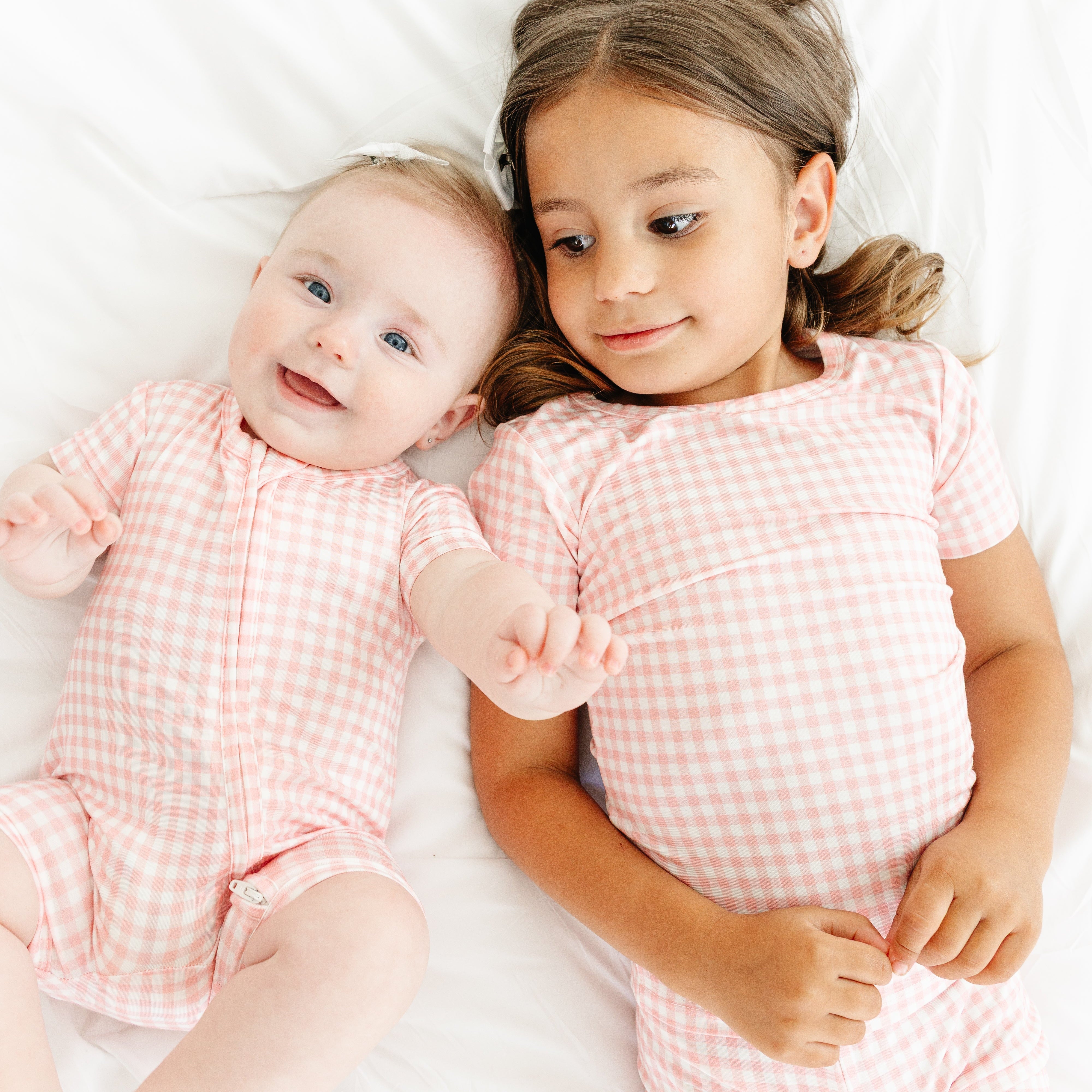 Toddler and baby girl wearing matching Sugar Gingham bamboo pajama sets from Motette