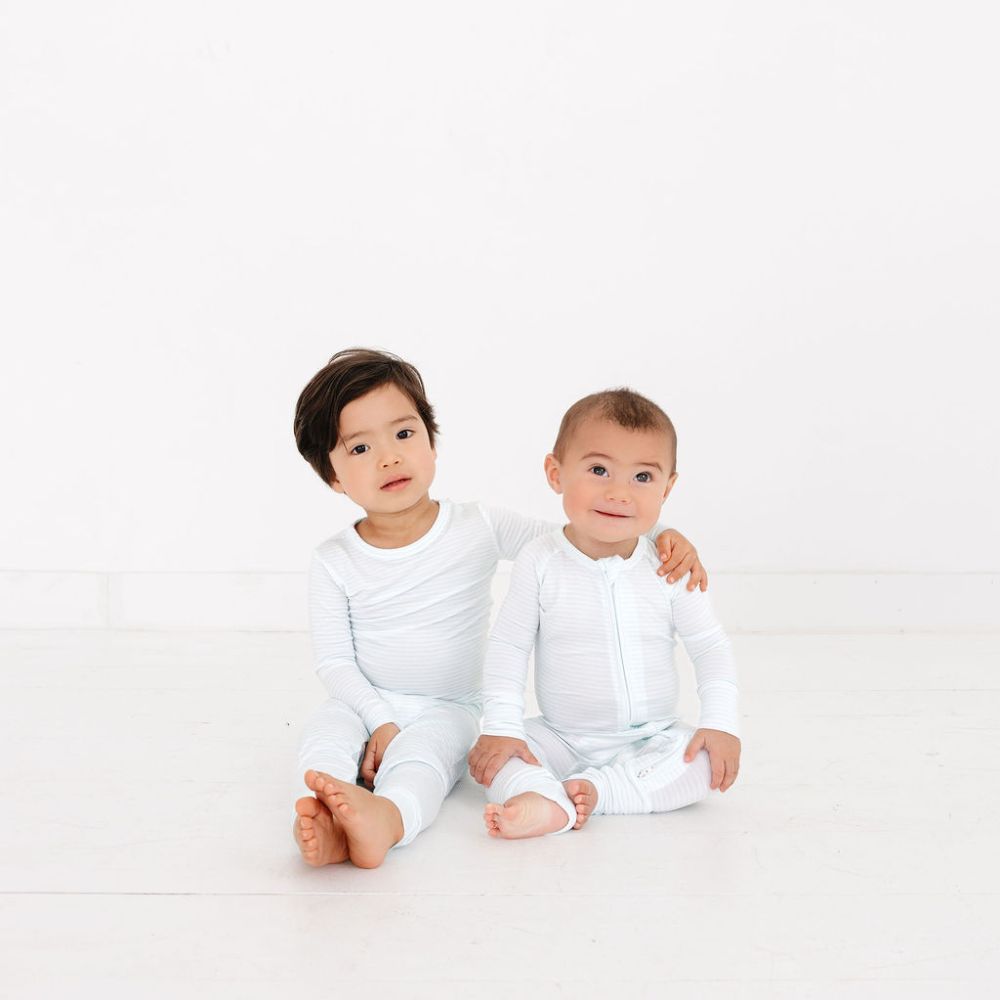 Toddler hugging baby sibling in matching Cloud Stripe bamboo pajamas by Motette – mommy and me matching styles for siblings