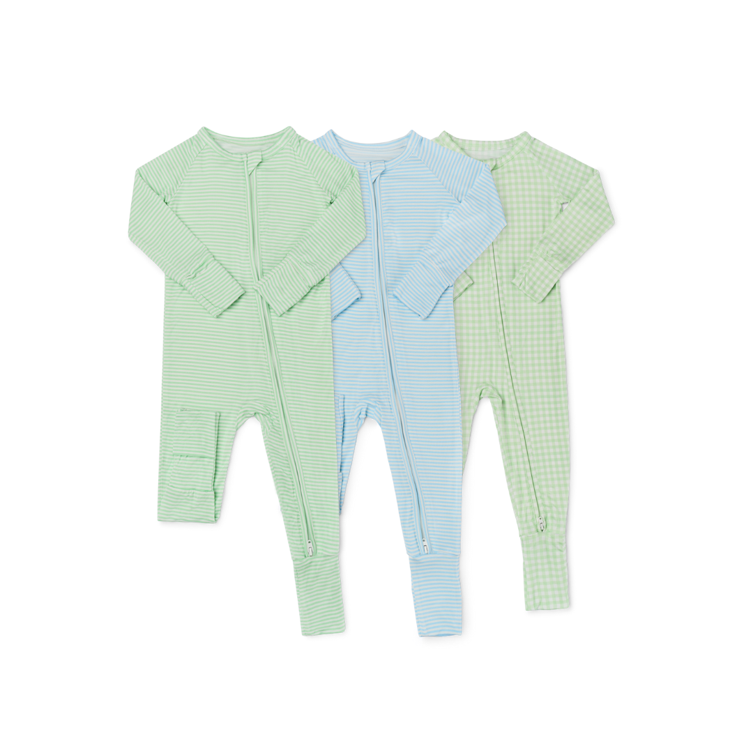 Flat lay of three bamboo baby sleepers in green checkered, green stripe, and blue stripe prints, displayed on a white background