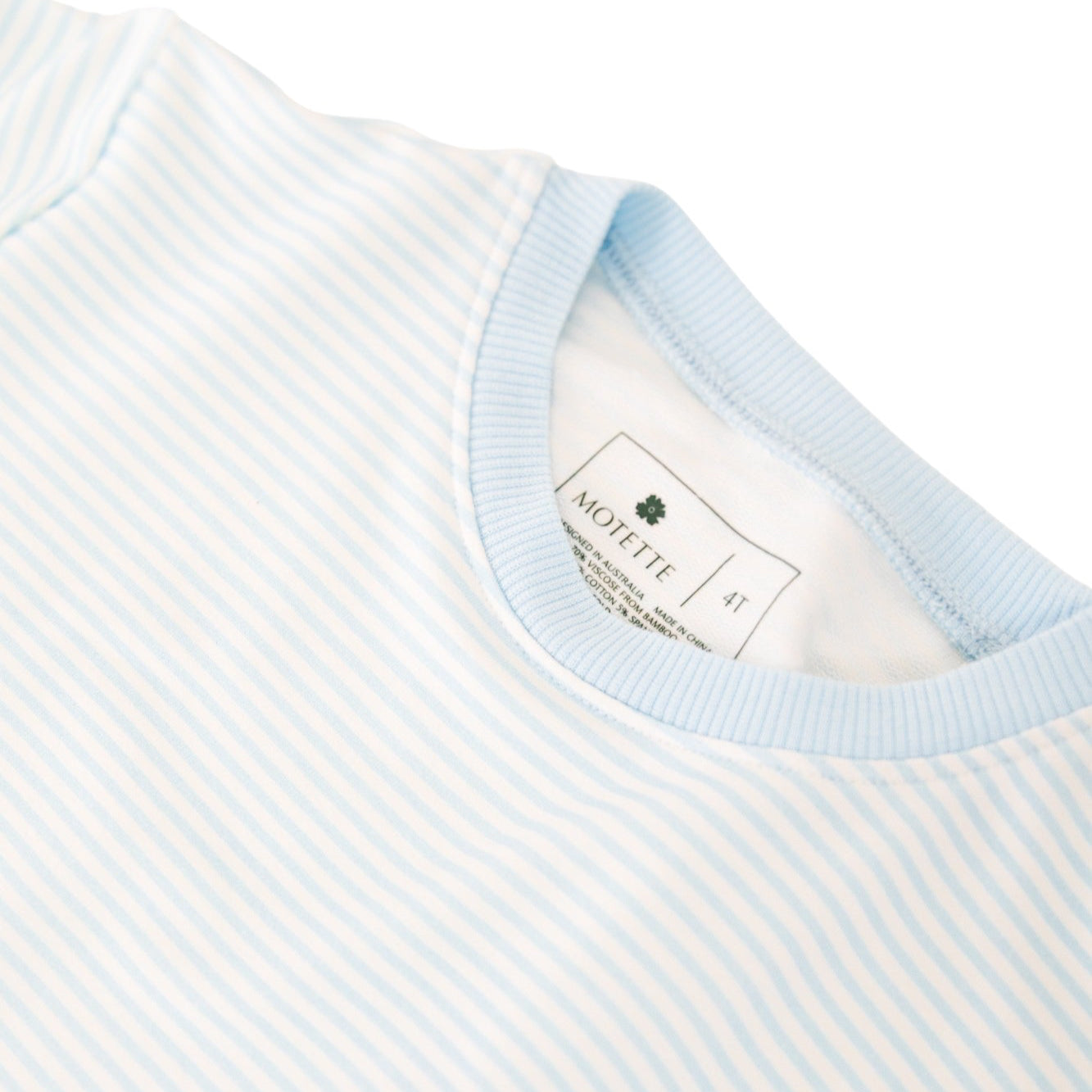 Flat lay of Motette’s blue striped bamboo lounger sweatsuit top and tag free label