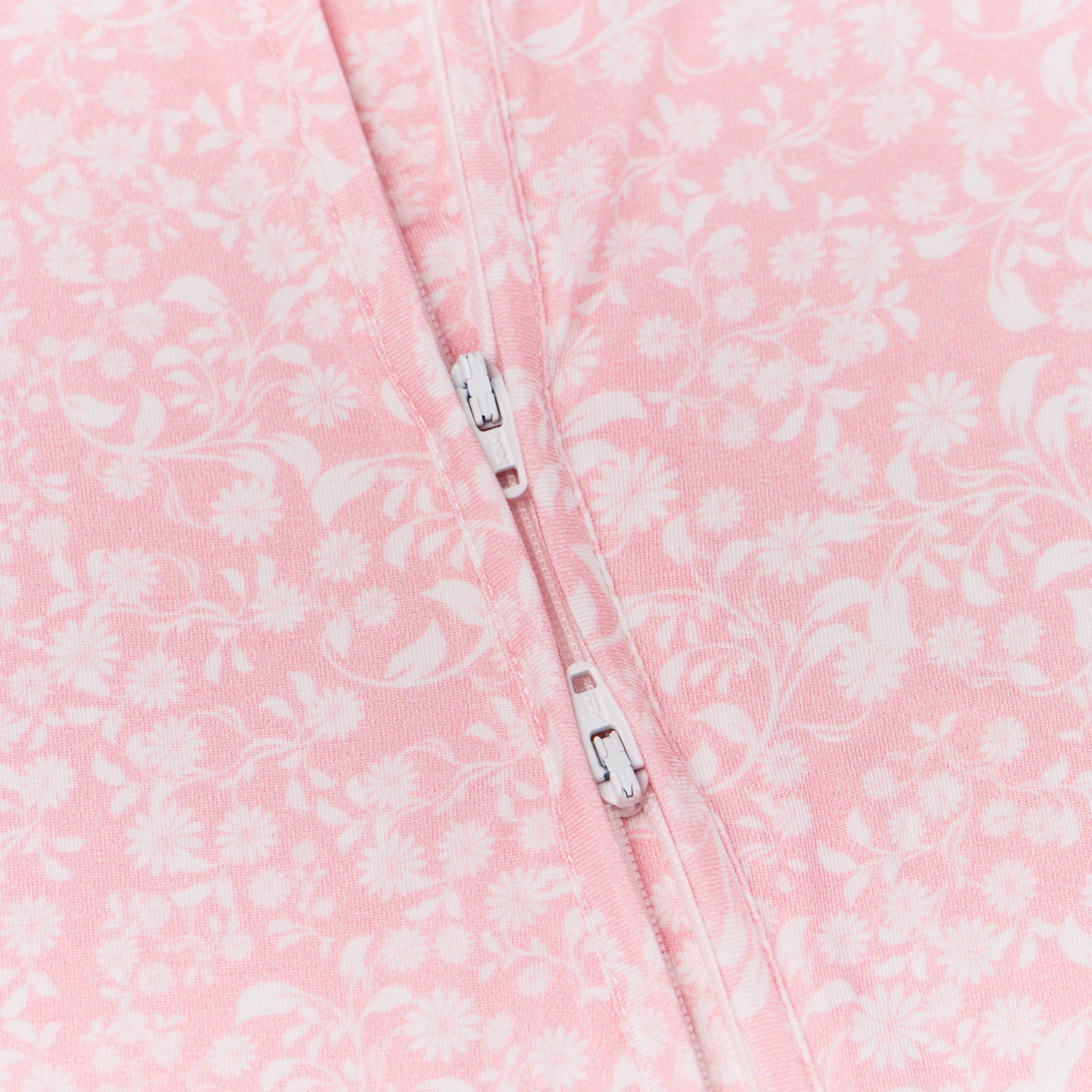 Detail shot of the two-way zipper on the sleeper, emphasizing ease of diaper changes
