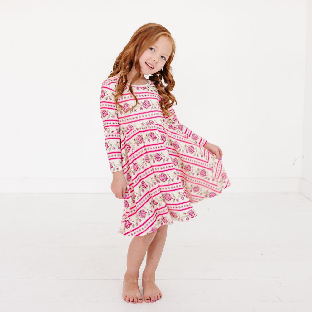 Girl standing wearing Pomegranate Soiree Bamboo Twirl Dress by Motette