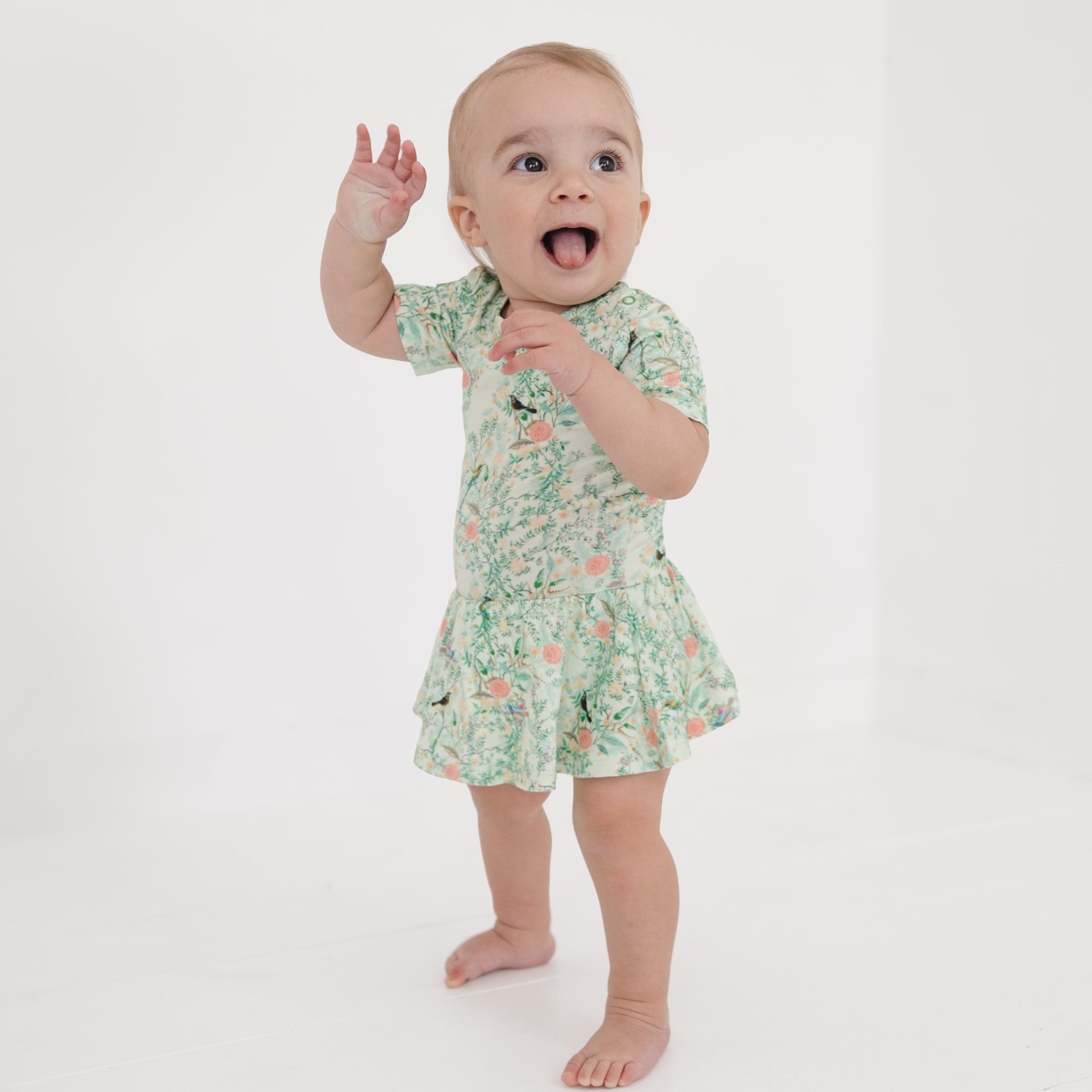 Baby girl wearing a green bamboo twirl dress with built-in bodysuit