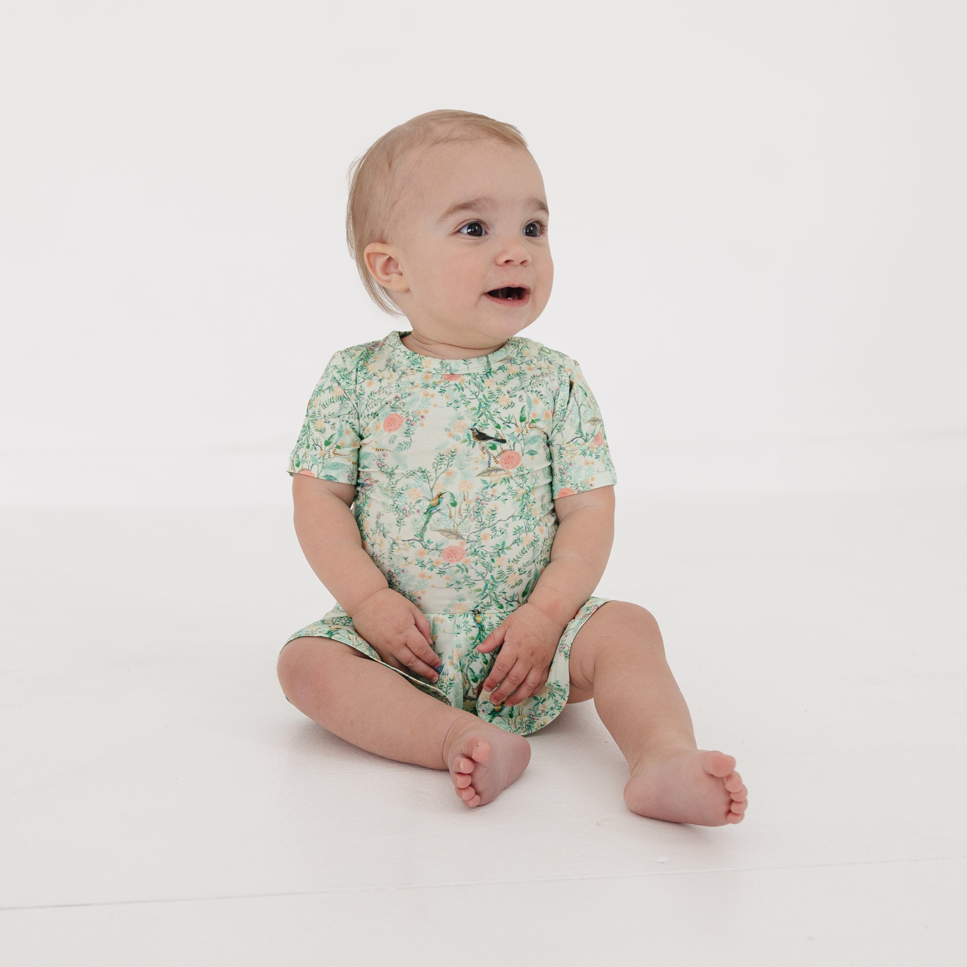 Close-up of baby girl in bamboo twirl dress, highlighting soft fabric and snap closure detail.