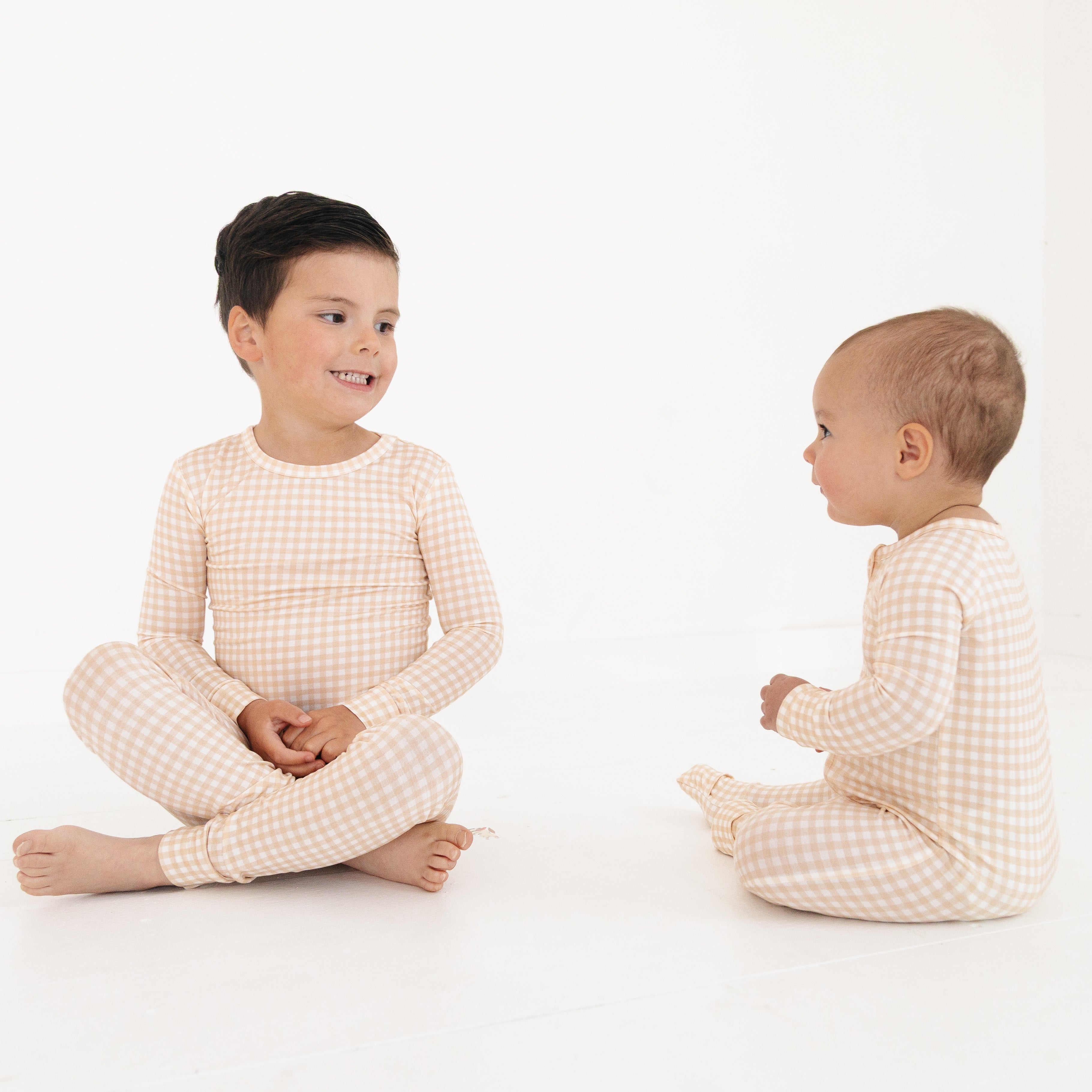 Toddler and baby matching sets in beige checkered bamboo sleeper and two piece pajamas