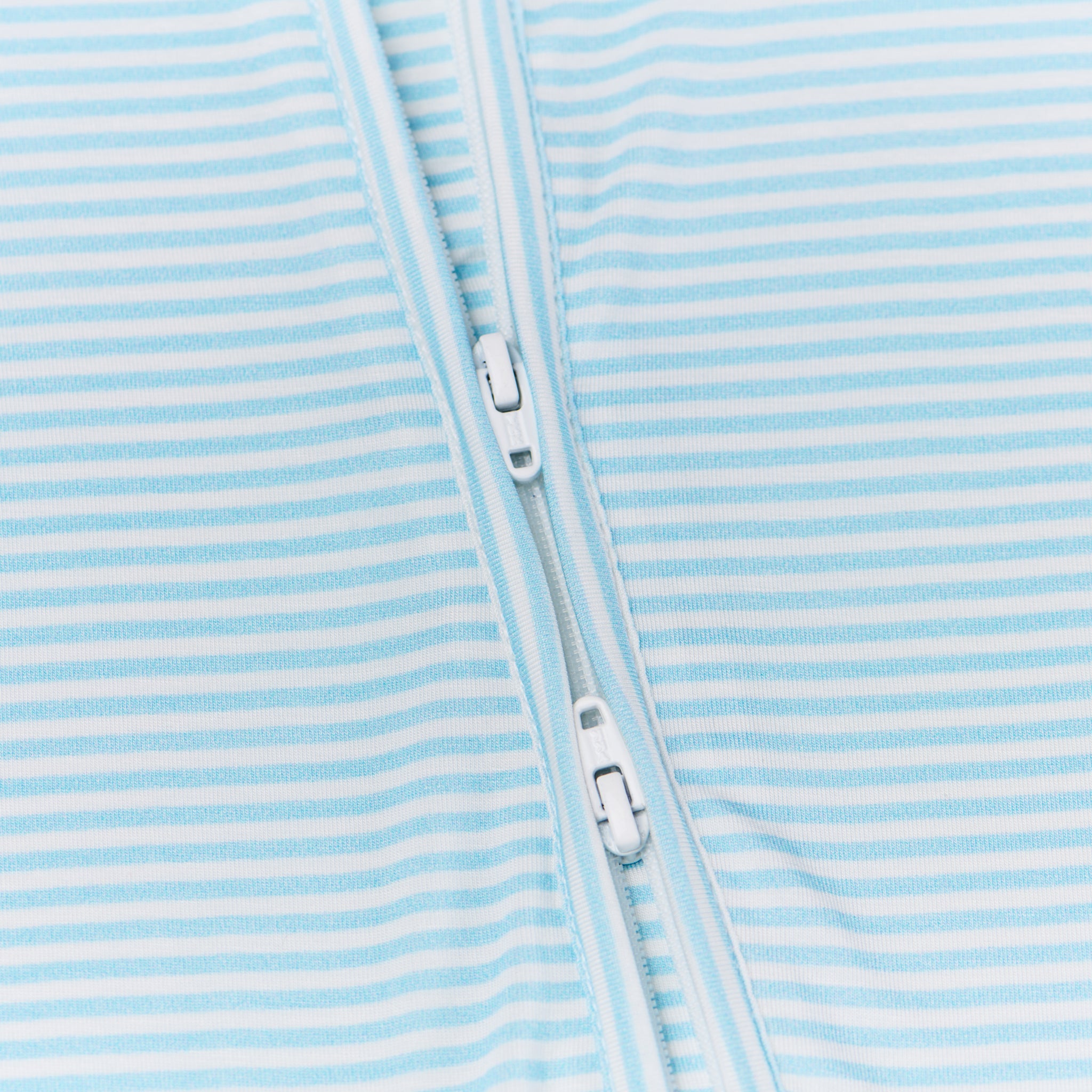 Close-up of the two-way zipper on the Seaside Stripe bamboo sleeper, emphasizing functionality for easy diaper changes.