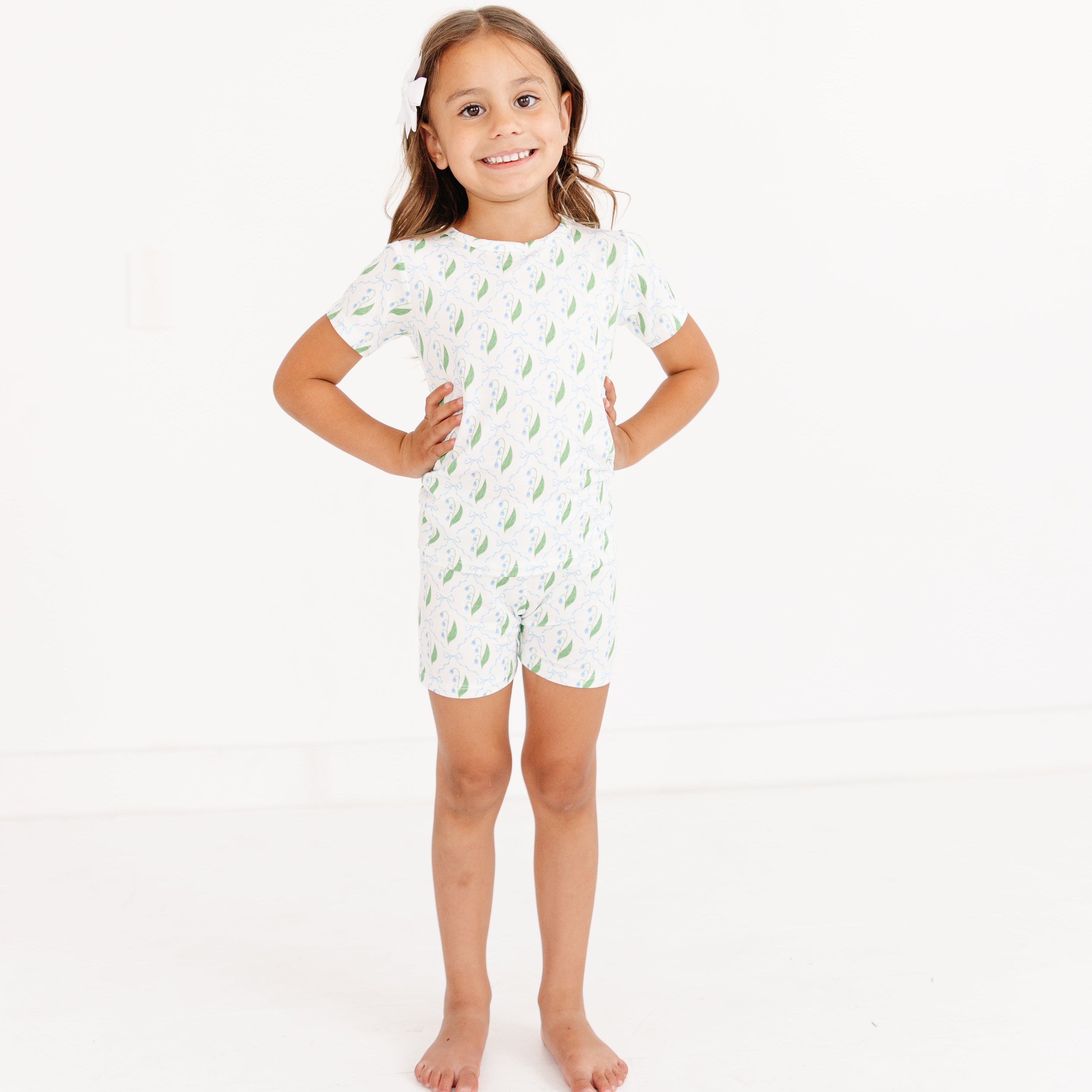 girl standing and wearing the Bluebell Bows bamboo pajama set by Motette