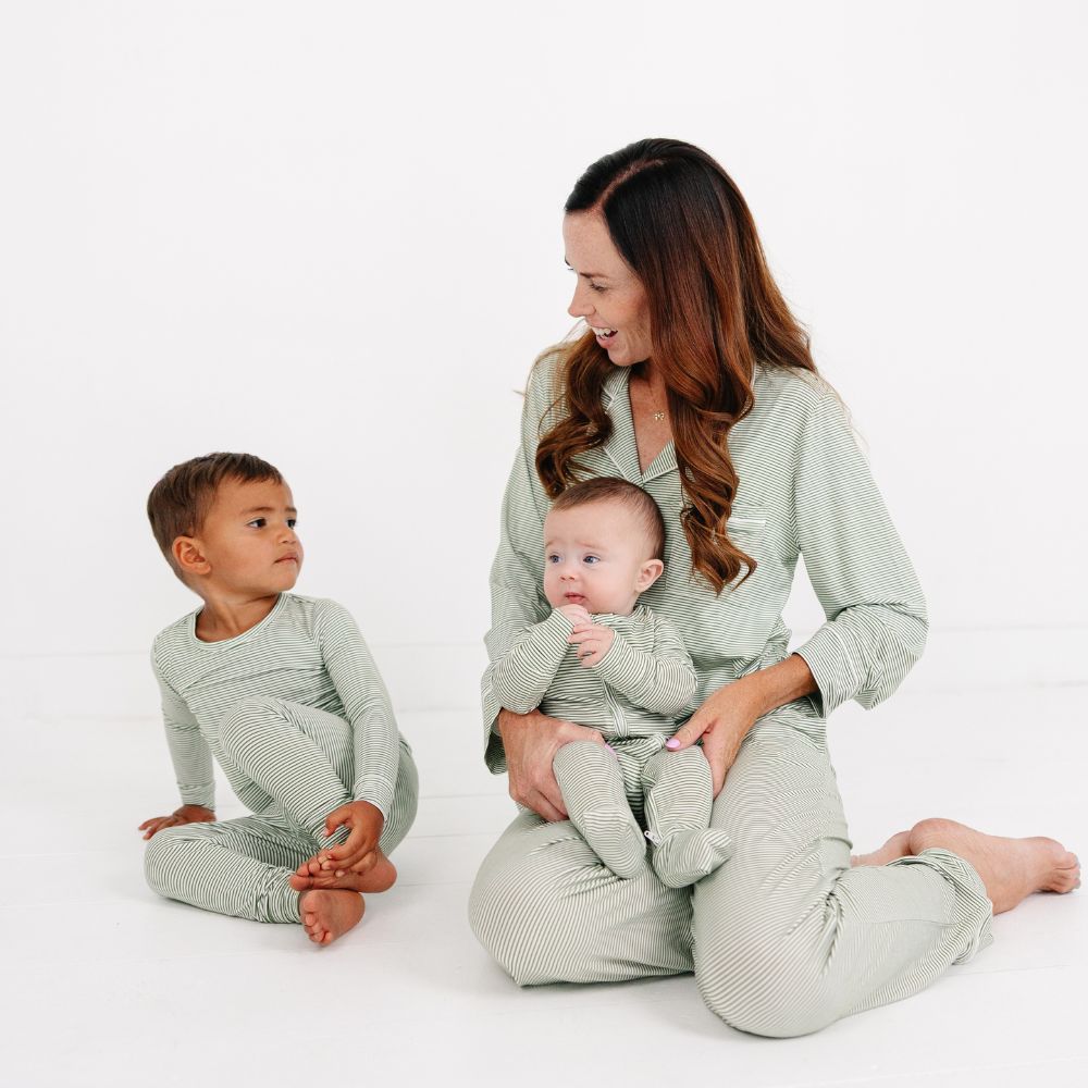 Mommy sitting with two children wearing matching Motette Evergreen Stripe Bamboo Pajamas.