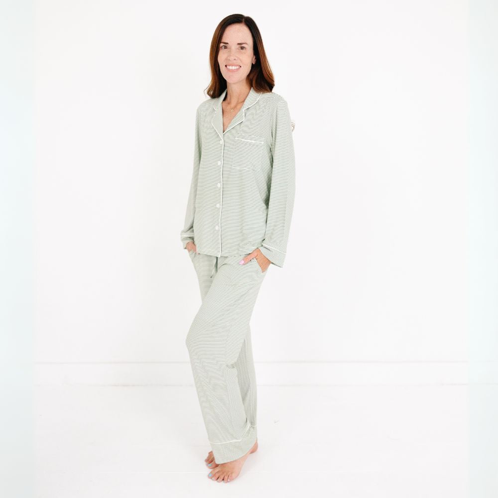 Mommy wearing the Motette Evergreen Stripe Bamboo Women's Pajama Set, featuring a soft green and white striped pattern, long-sleeve button-up top with white piping, and matching relaxed-fit pants with drawstring waist.