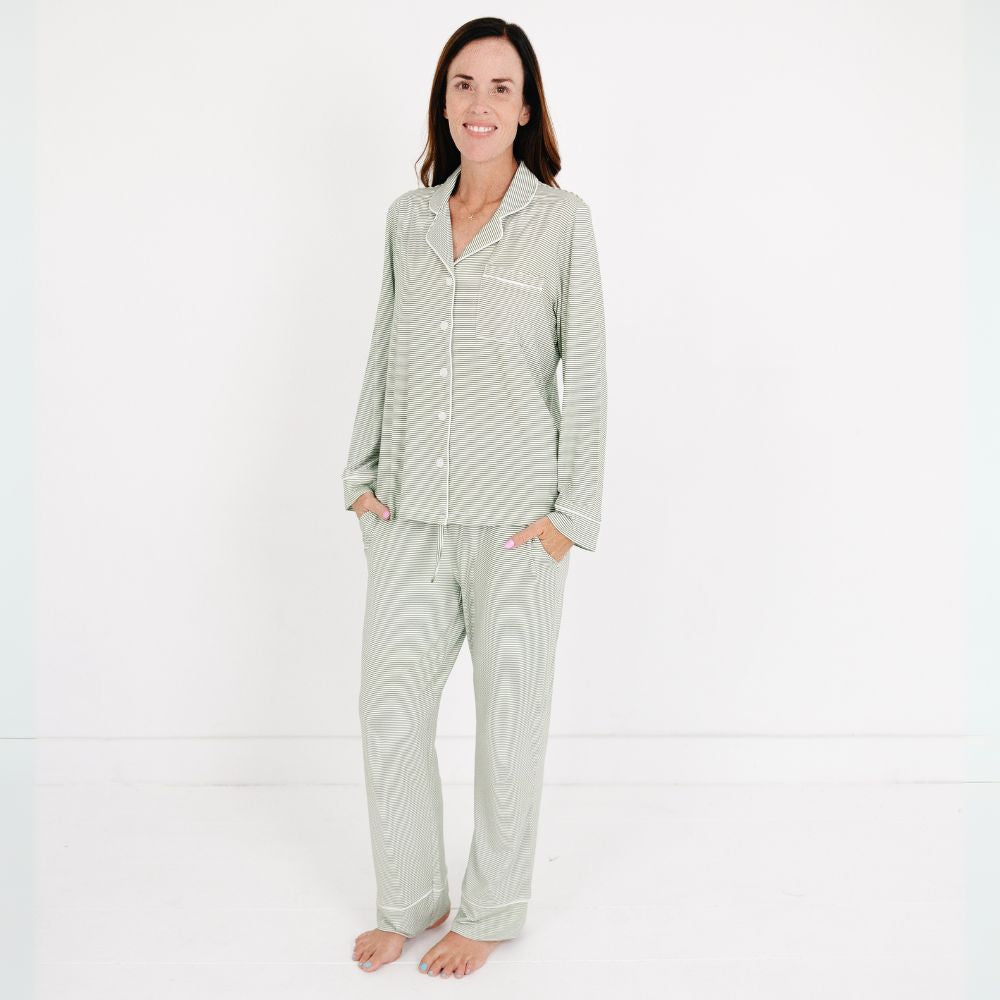Mommy wearing the Motette Evergreen Stripe Bamboo Women's Pajama Set, featuring a soft green and white striped pattern, long-sleeve button-up top with white piping, and matching relaxed-fit pants with drawstring waist.