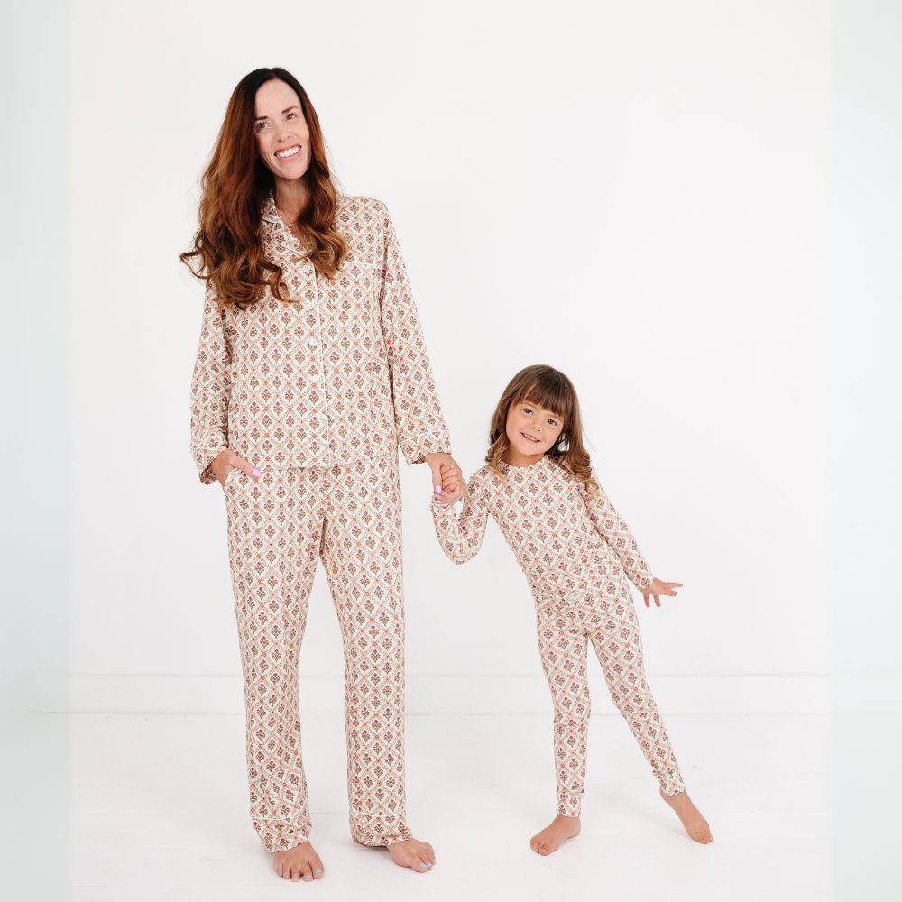 Mommy and daughter wearing matching Motette Holly Trellis Bamboo Pajama Sets, holding hands and smiling.