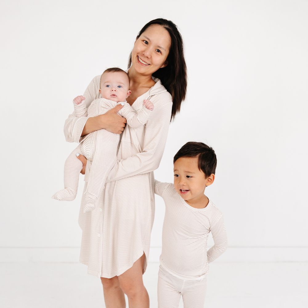 Mommy holding baby and standing beside older son, all wearing matching Motette Oatmeal Stripe Bamboo Pajama Sets.