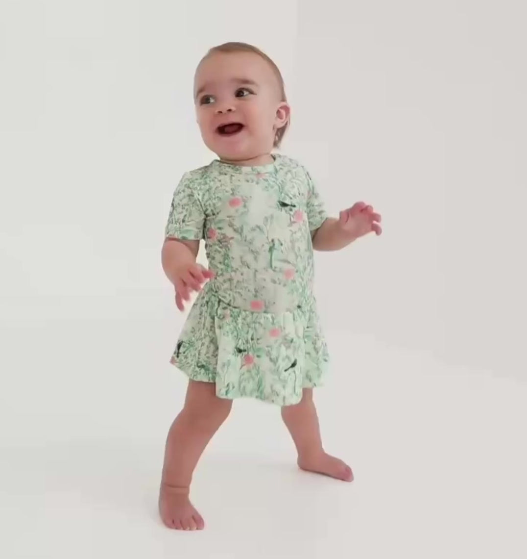 video of baby girl wearing a green bamboo twirl dress with built-in bodysuit