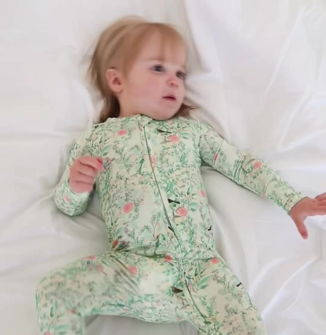 Video of baby girl wearing green floral bamboo sleeper