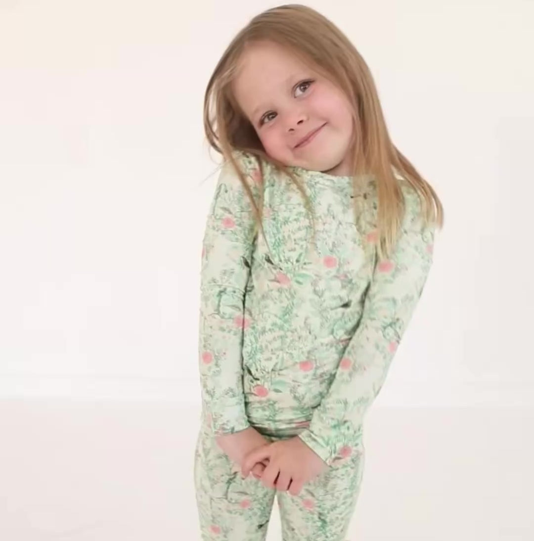 video of toddler girl standing in green floral bamboo two-piece pajamas, smiling and showing full outfit.