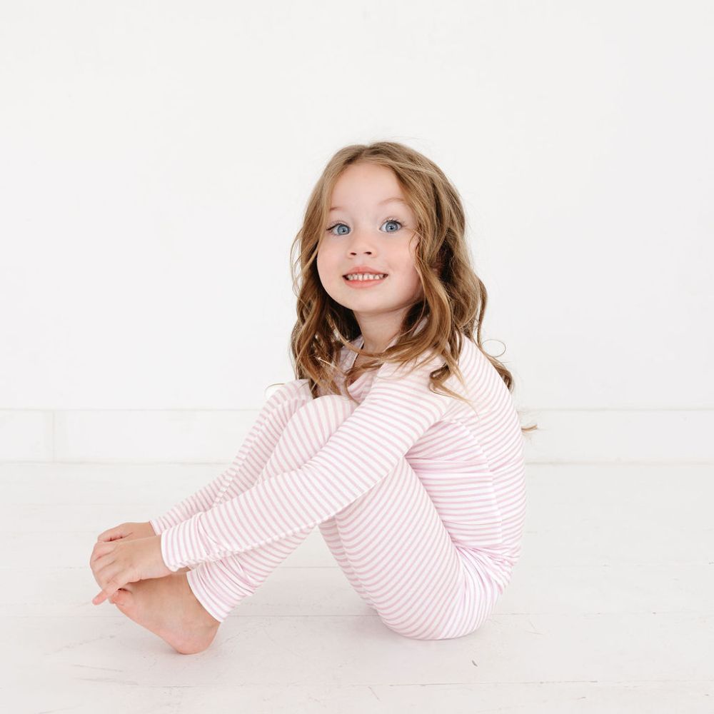 Toddler girl sitting in Ballet Stripe bamboo pajamas – eczema friendly, ultra-soft toddler sleepwear by Motette

